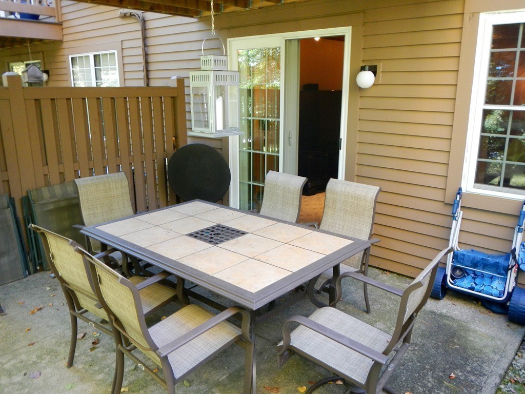 208 B Ridgefield Circle, Unit B Clinton, MA 01510 - Photo 18 of 24 a view of a patio with a table and chairs and potted plants
