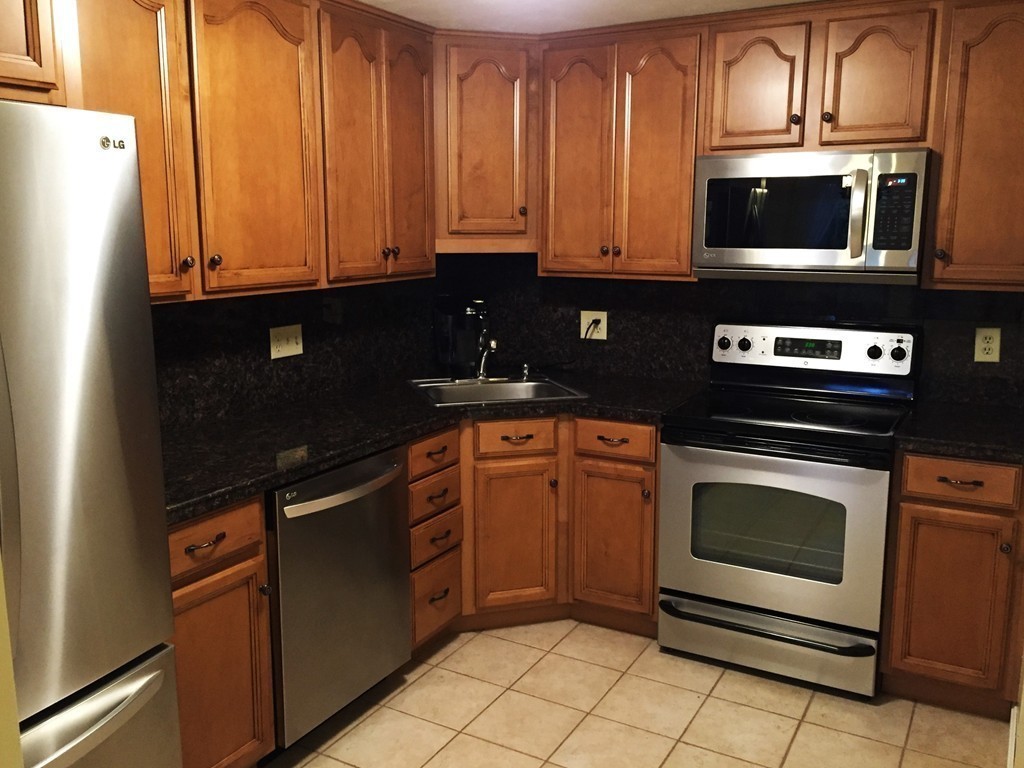 208 B Ridgefield Circle, Unit B Clinton, MA 01510 - Photo 8 of 24 a kitchen with granite countertop a stove and a microwave