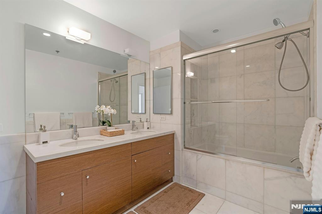 3219 City Place Edgewater, NJ 07020 - Photo 13 of 30 a bathroom with a double vanity sink mirror and shower