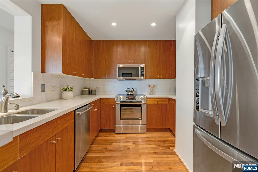 3219 City Place Edgewater, NJ 07020 - Photo 7 of 30 a kitchen with stainless steel appliances granite countertop a refrigerator sink and stove
