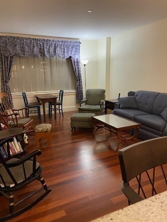 116 Rantoul Street, Unit 408 Beverly, MA 01915 - Photo 15 of 27 a living room with furniture and a wooden floor