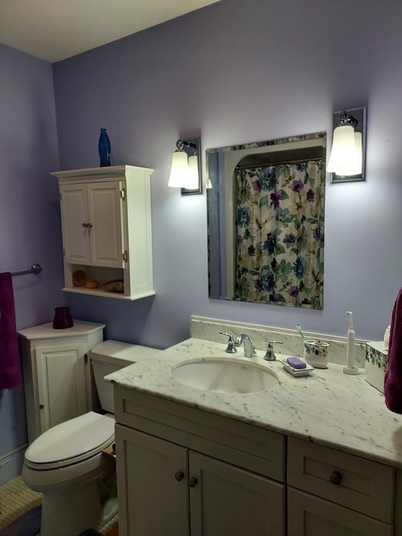 116 Rantoul Street, Unit 408 Beverly, MA 01915 - Photo 19 of 27 a bathroom with a toilet a sink and mirror