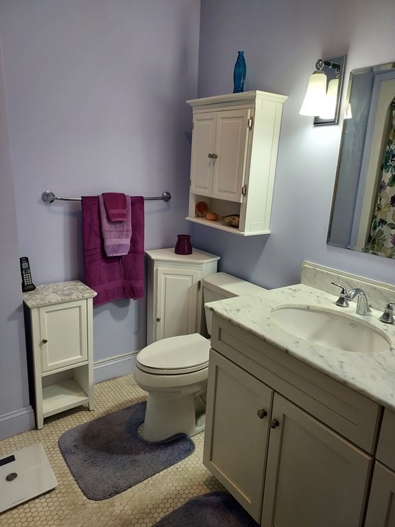 116 Rantoul Street, Unit 408 Beverly, MA 01915 - Photo 20 of 27 a bathroom with a toilet sink and mirror