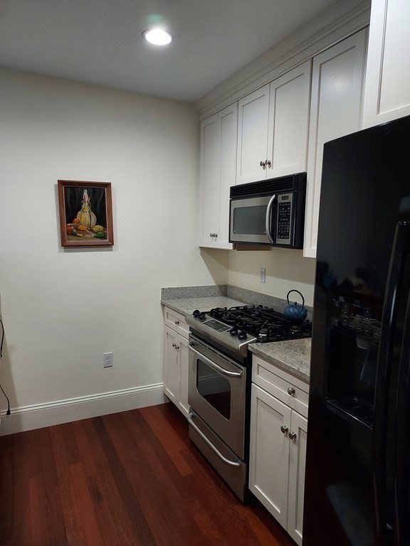 116 Rantoul Street, Unit 408 Beverly, MA 01915 - Photo 10 of 27 a kitchen with a stove and a microwave