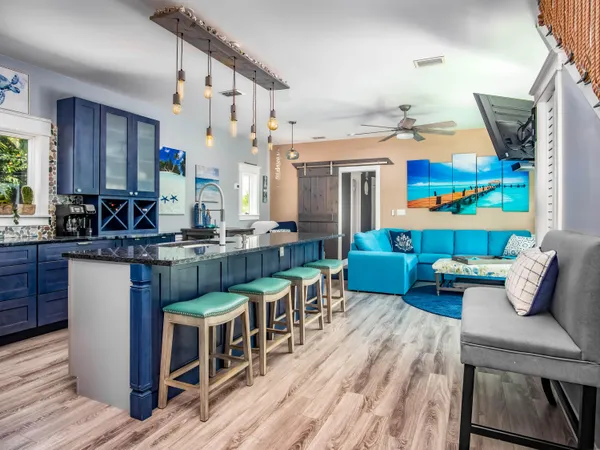 a kitchen with stainless steel appliances granite countertop a stove top oven a sink dishwasher and cabinets with wooden floor