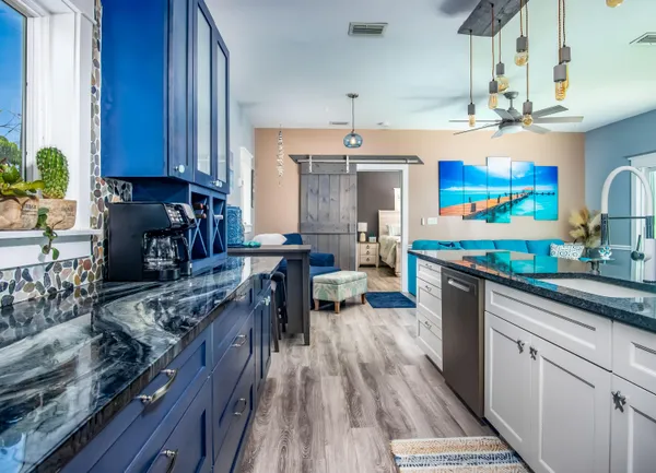 a stove top oven sitting inside of a kitchen with granite countertop wooden cabinets