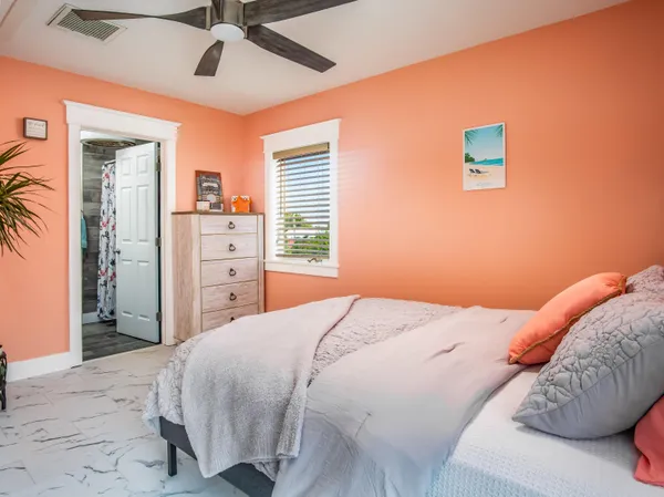 a bedroom with a large bed and a chandelier