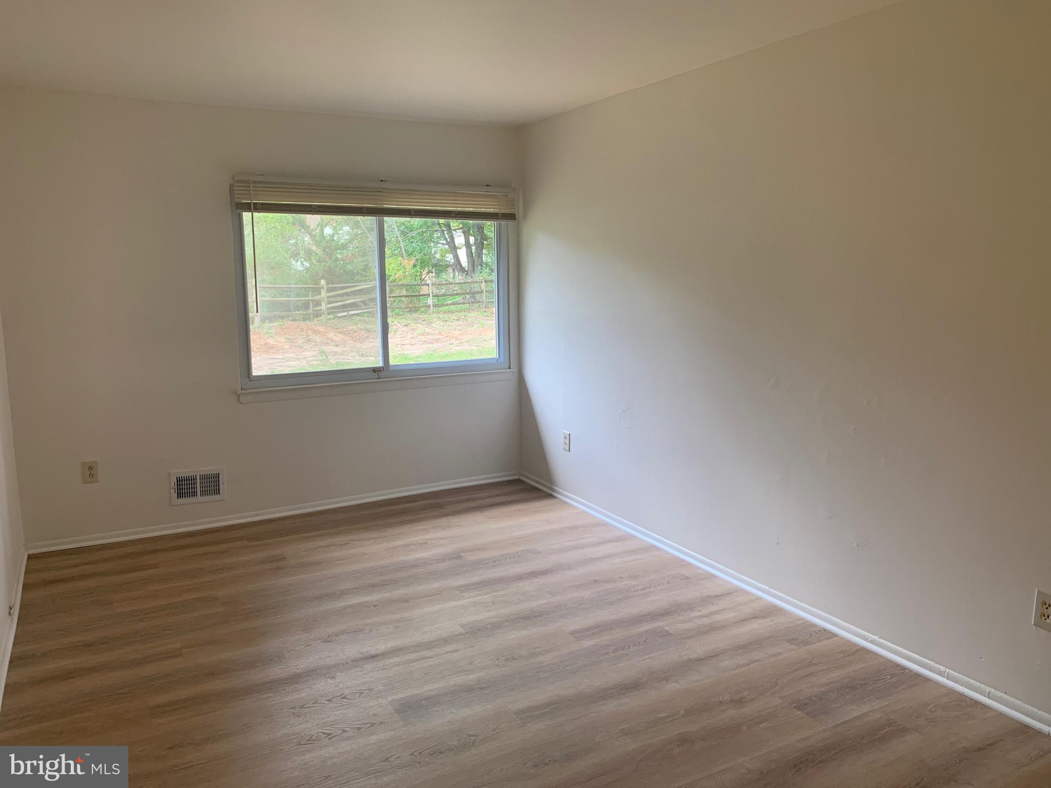 5656 Shadow Fall Terrace Columbia, MD 21045 - Photo 14 of 41 an empty room with wooden floor and windows