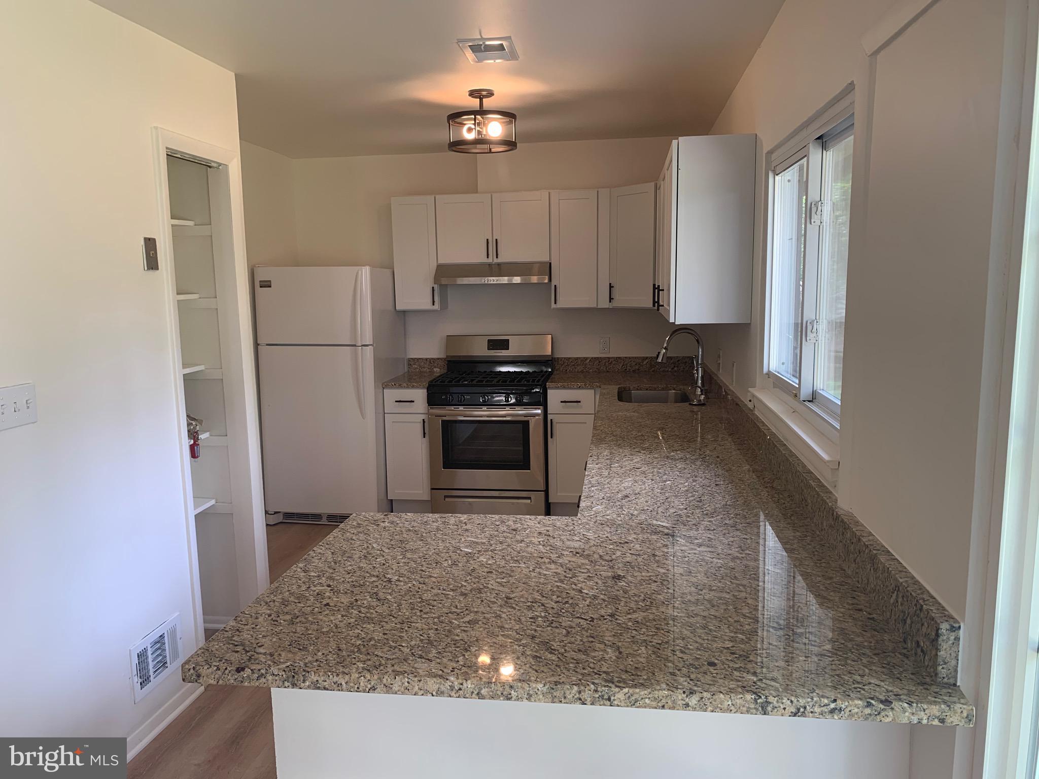 5656 Shadow Fall Terrace Columbia, MD 21045 - Photo 8 of 41 a kitchen with kitchen island a counter top space stainless steel appliances and a refrigerator