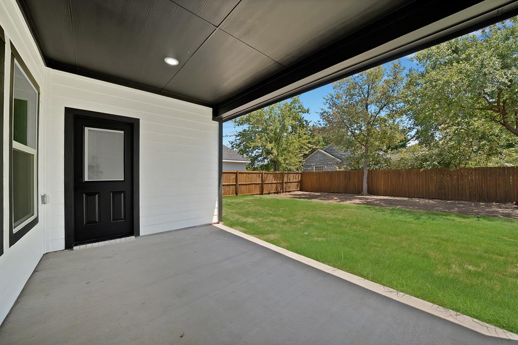 805 Tierney Road Fort Worth, TX 76112 - Photo 33 of 36 Covered concrete patio with recessed lighting, offering access to an expansive fenced yard featuring a manicured lawn and mature trees