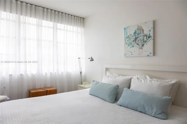 a bedroom with a bed and a painting on the wall