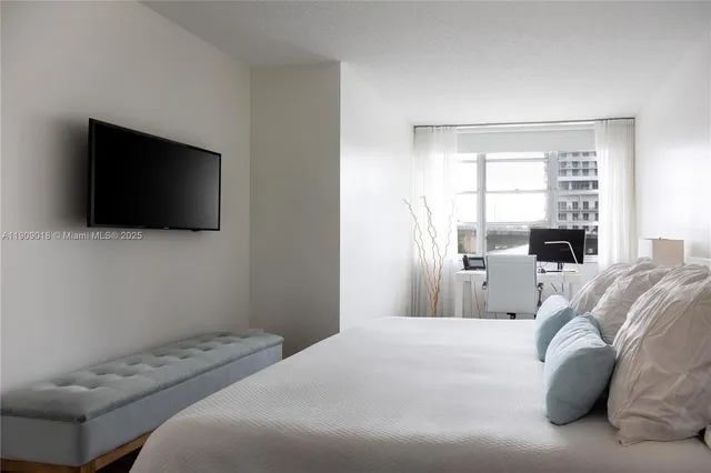 a bedroom with a bed and a flat screen tv