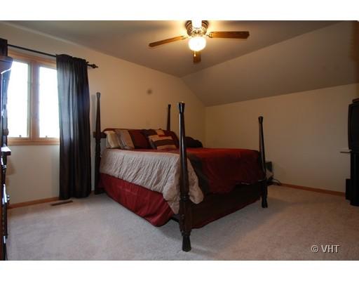13331 Cathy Lane Plainfield, IL 60585 - Photo 14 of 16 a bedroom with a bed window and a chandelier