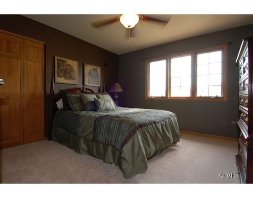 13331 Cathy Lane Plainfield, IL 60585 - Photo 15 of 16 a bedroom with a bed and a chandelier