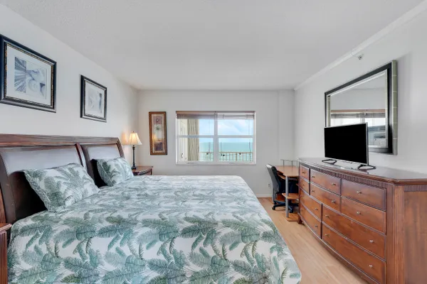 a bedroom with a large bed and a flat screen tv