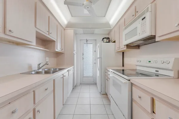 a kitchen with a sink dishwasher stove and cabinets