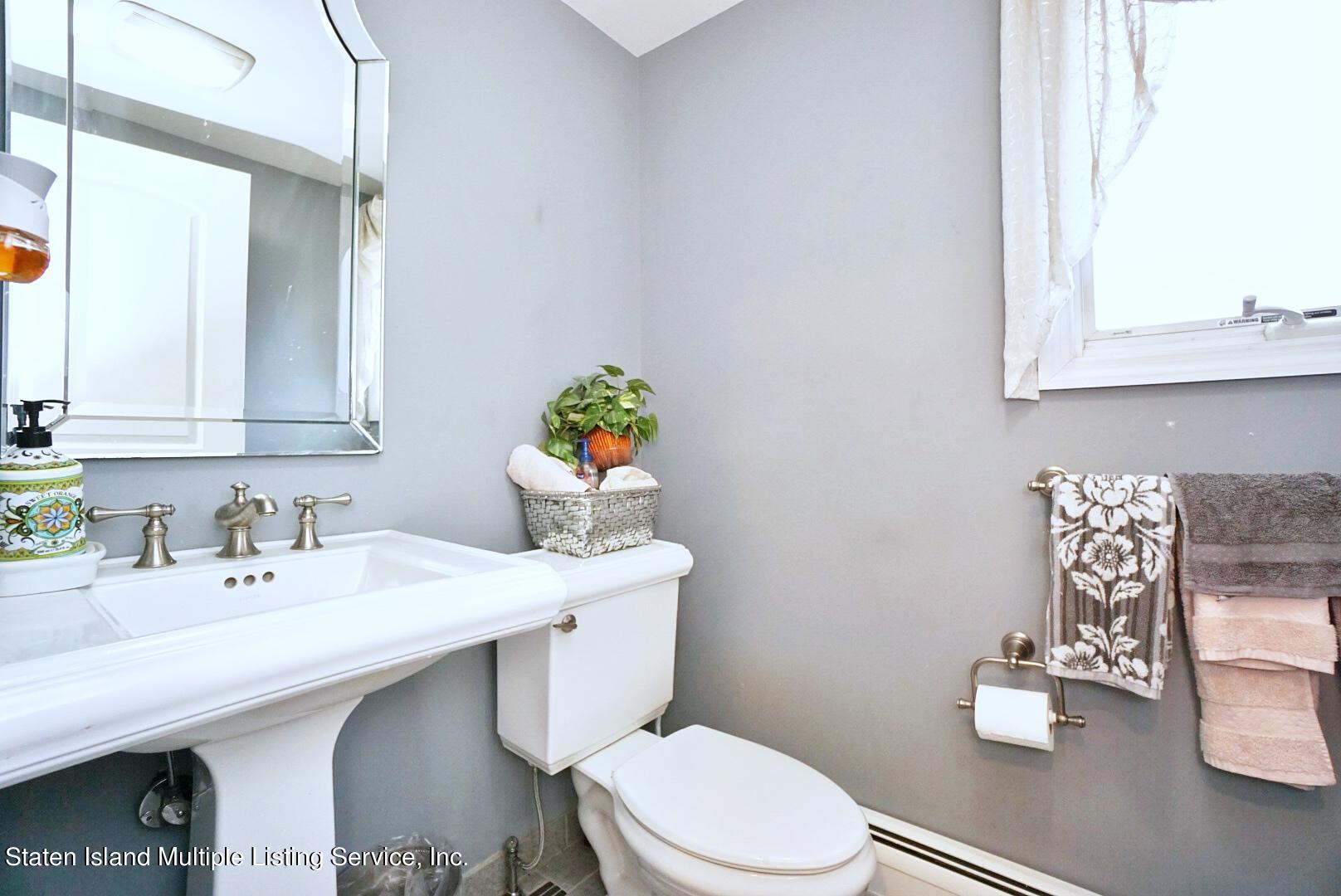 65 Lander Avenue Staten Island, NY 10314 - Photo 25 of 53 a bathroom with a sink a toilet and mirror