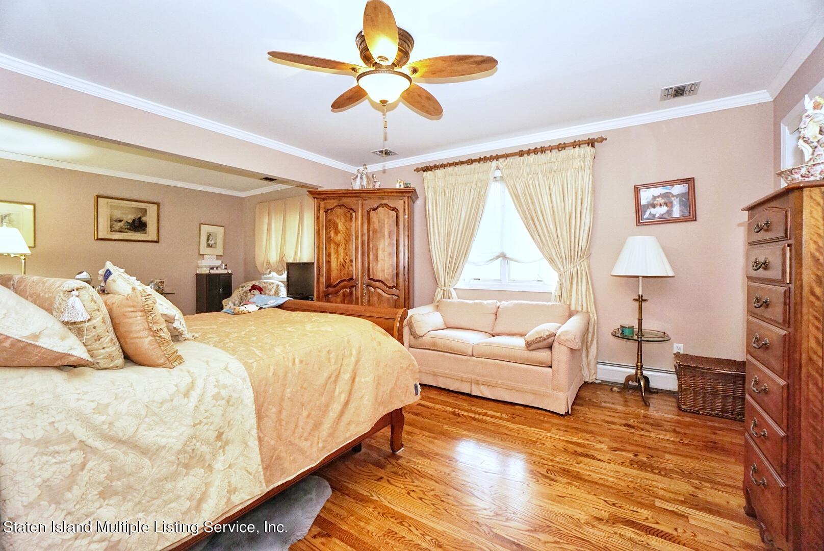 65 Lander Avenue Staten Island, NY 10314 - Photo 29 of 53 a bedroom with a large bed and a chandelier