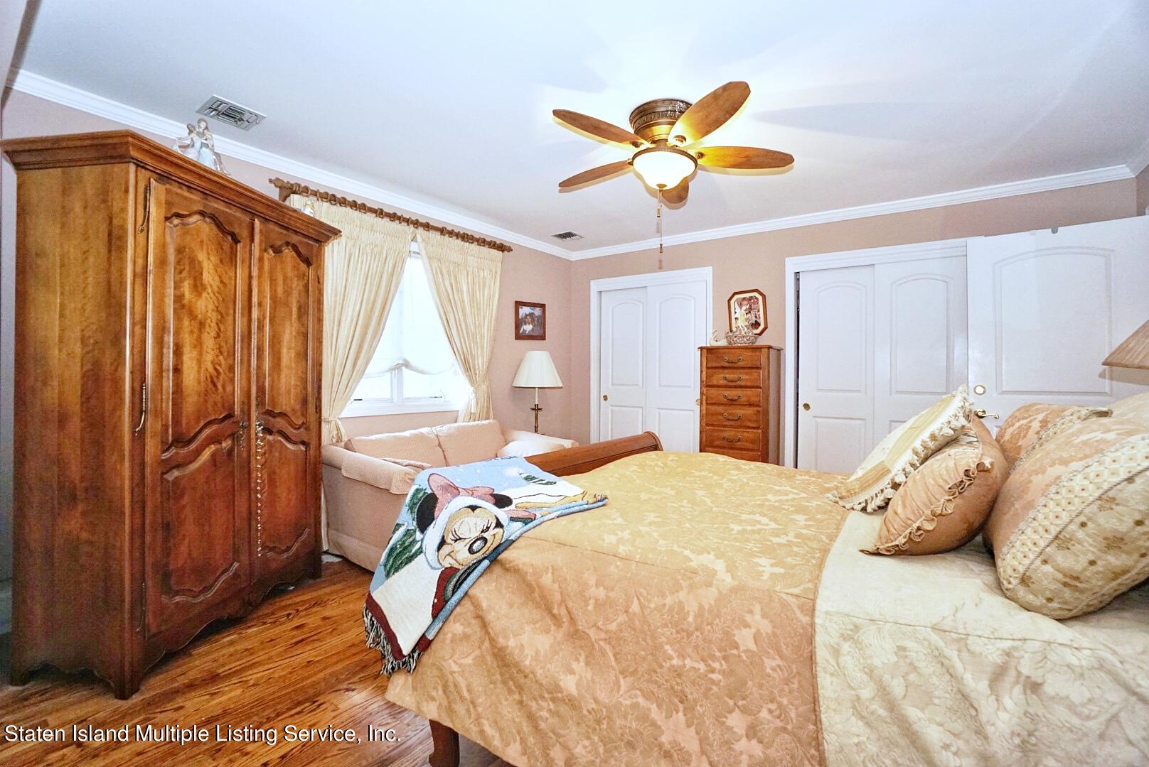65 Lander Avenue Staten Island, NY 10314 - Photo 30 of 53 a bedroom with a bed and a chandelier