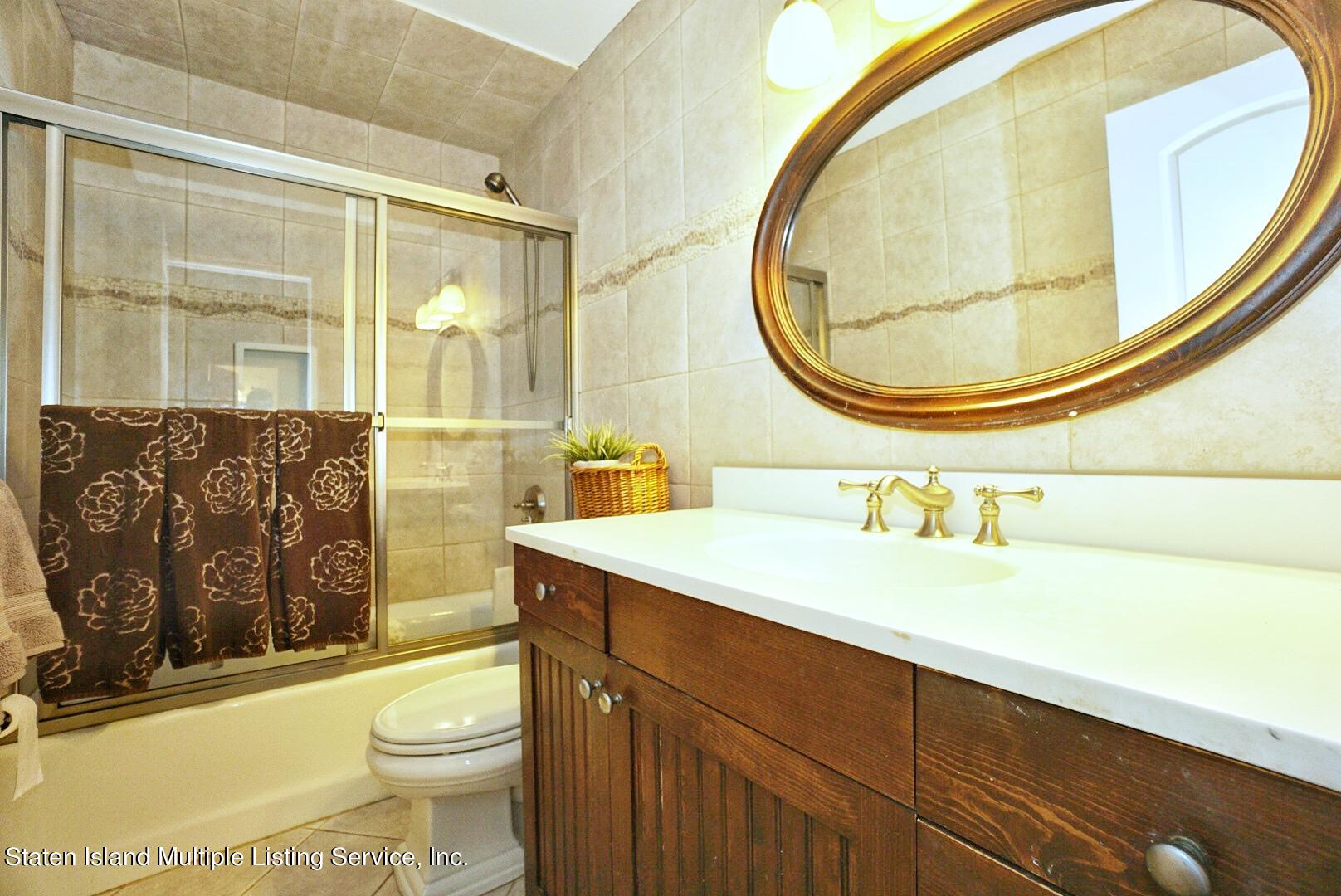 65 Lander Avenue Staten Island, NY 10314 - Photo 33 of 53 a bathroom with a sink a toilet and a mirror