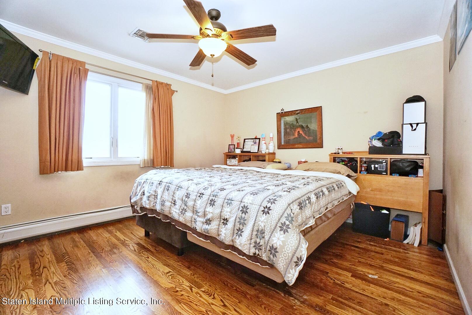 65 Lander Avenue Staten Island, NY 10314 - Photo 39 of 53 a bedroom with a bed lamp closet and large window