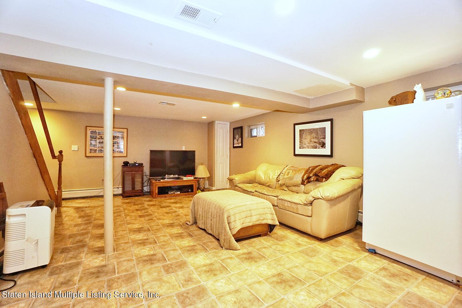 65 Lander Avenue Staten Island, NY 10314 - Photo 44 of 53 a living room with couches and a flat screen tv