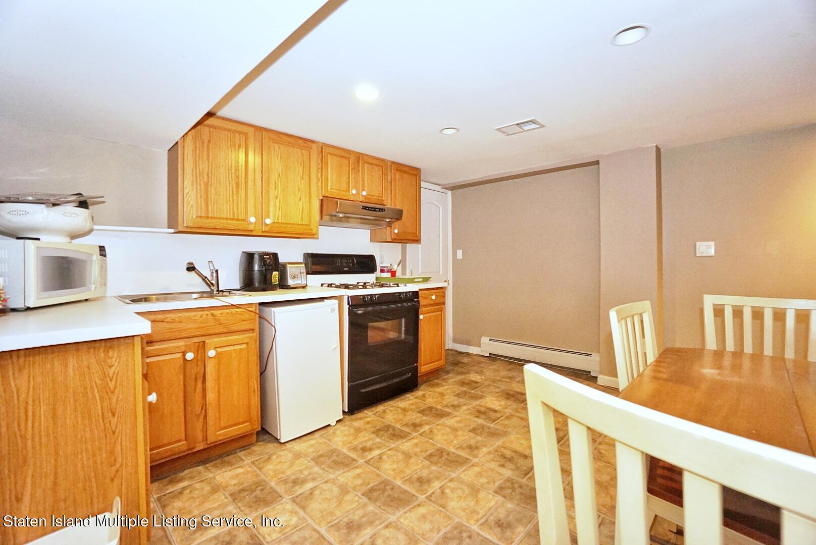 65 Lander Avenue Staten Island, NY 10314 - Photo 46 of 53 a kitchen with a stove a sink and a refrigerator