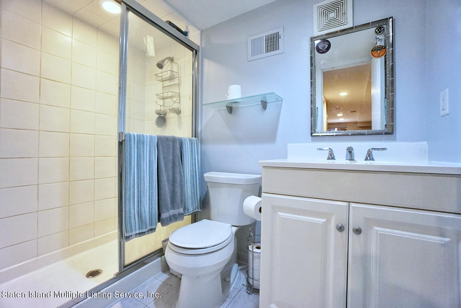 65 Lander Avenue Staten Island, NY 10314 - Photo 48 of 53 a bathroom with a sink vanity mirror and toilet
