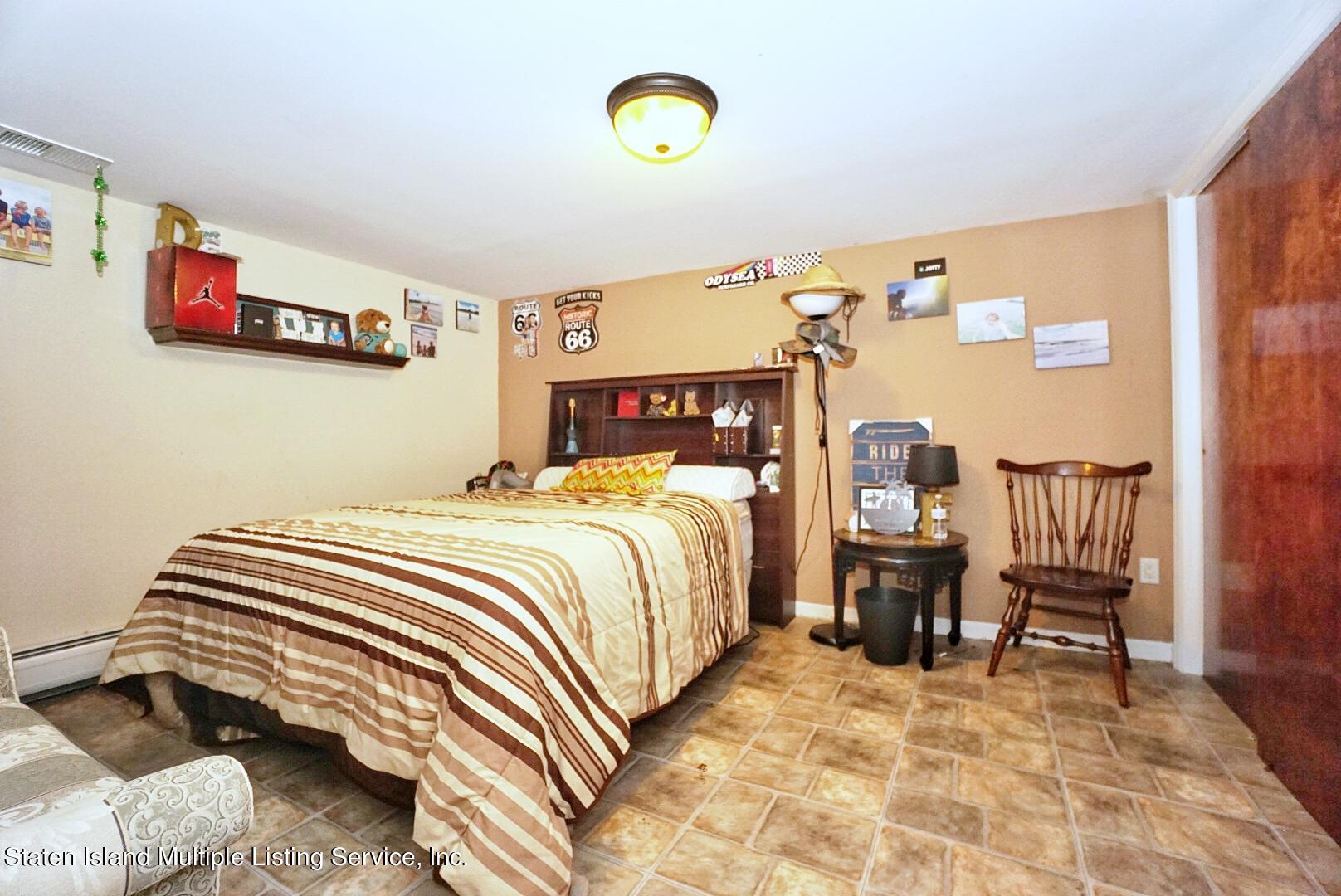 65 Lander Avenue Staten Island, NY 10314 - Photo 52 of 53 a bedroom with a bed and a dresser in it