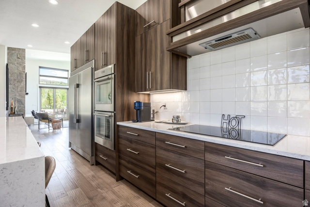 140 West Vista Road Kamas, UT 84036 - Photo 28 of 101 Integrated stainless steel appliances, wood-finish flooring, white subway tile backsplash, and light-toned countertops