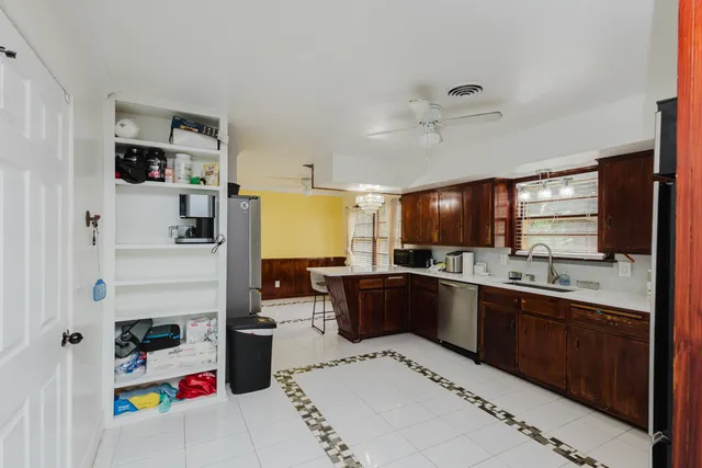a kitchen with stainless steel appliances kitchen island granite countertop a sink dishwasher stove and cabinets