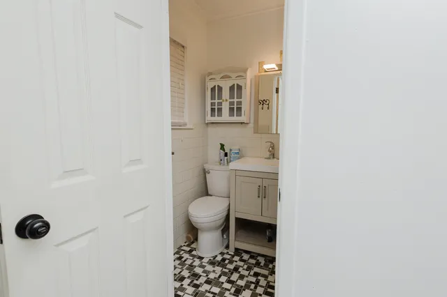 a bathroom with a toilet a sink and a mirror