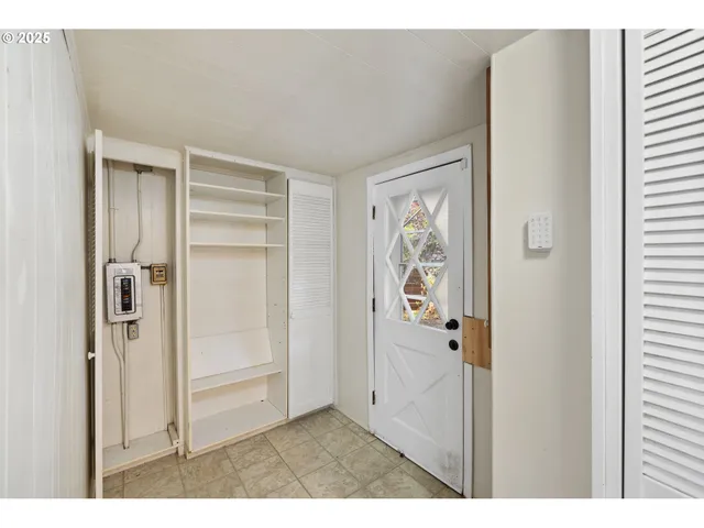 a view of a hallway with wooden floor and closet area