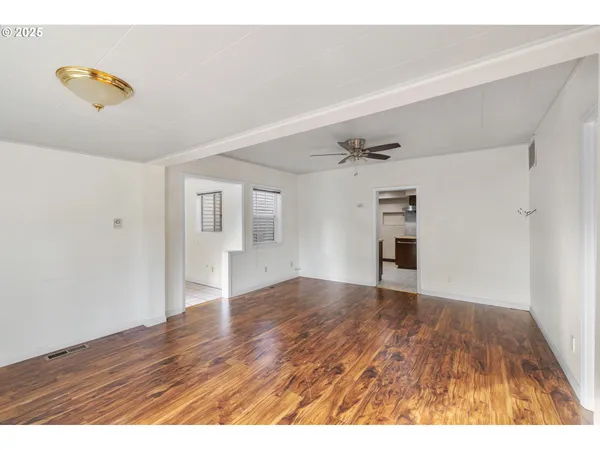 a view of empty room with wooden floor