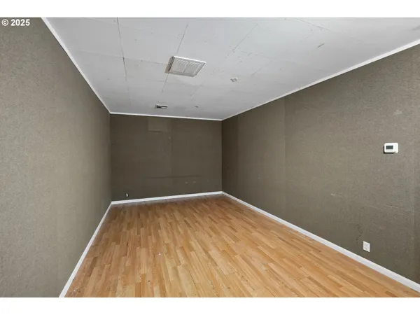 a view of an empty room with wooden floor