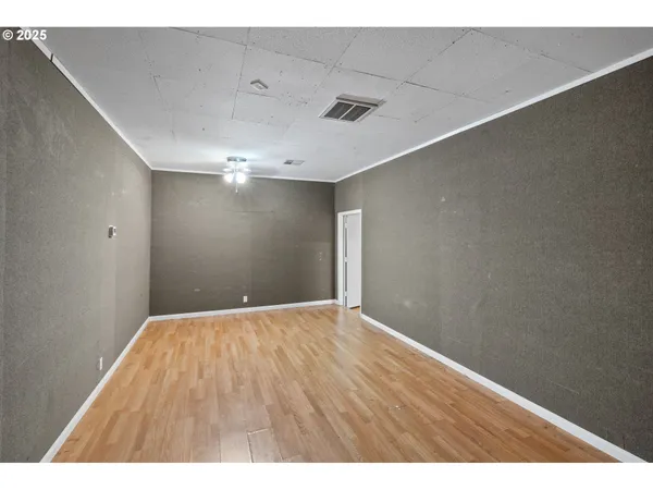 a view of an empty room with wooden floor