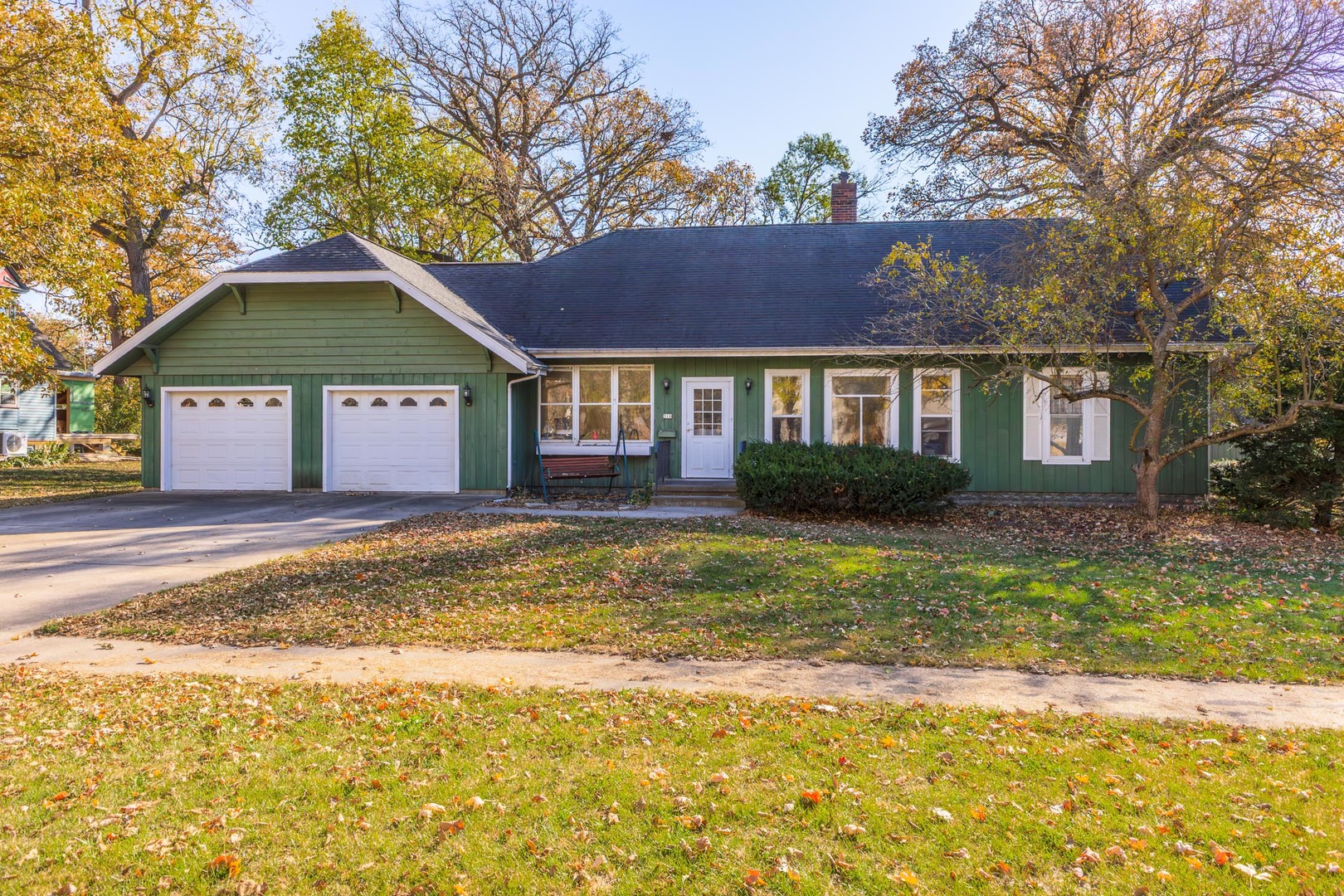 a front view of a house with a yard and trees