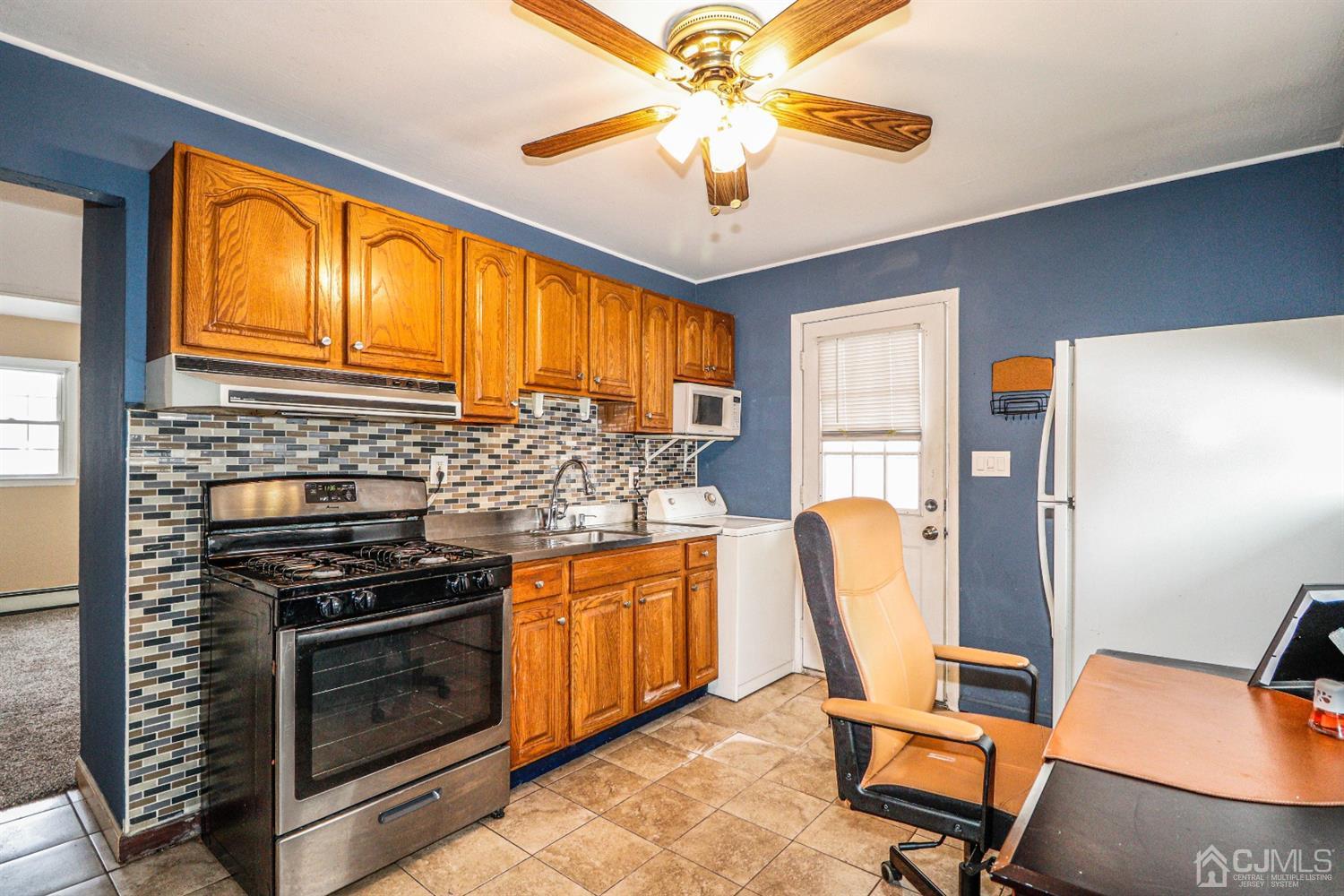 17 Dayton Road Edison, NJ 08817 - Photo 5 of 25 a kitchen with stainless steel appliances granite countertop a stove top oven a dining table and chairs with wooden floor