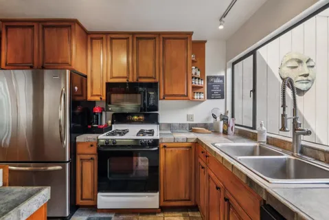 a kitchen with stainless steel appliances granite countertop a refrigerator stove and sink