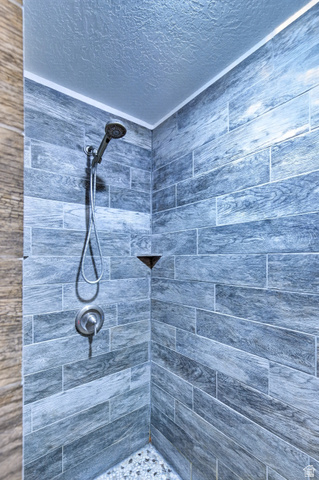 161 West 950 South, Unit Q1 St. George, UT 84770 - Photo 19 of 37 Bathroom featuring a textured ceiling and a tile shower