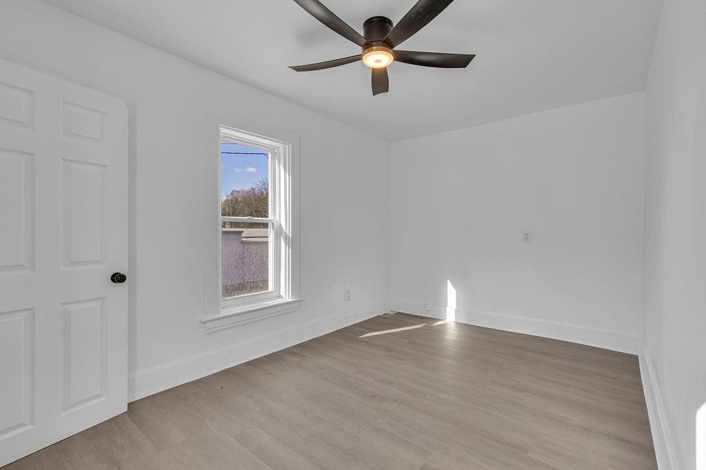 498 Blockhouse Run Road New Brighton, PA 15066 - Photo 18 of 23 an empty room with wooden floor fan and windows