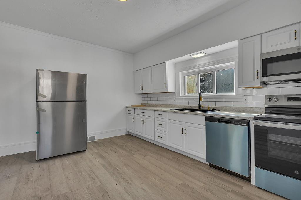 498 Blockhouse Run Road New Brighton, PA 15066 - Photo 4 of 23 a kitchen with granite countertop a refrigerator stove a sink and dishwasher with wooden floor