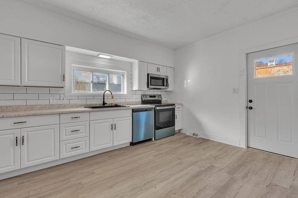 498 Blockhouse Run Road New Brighton, PA 15066 - Photo 6 of 23 a kitchen with granite countertop white cabinets and stainless steel appliances