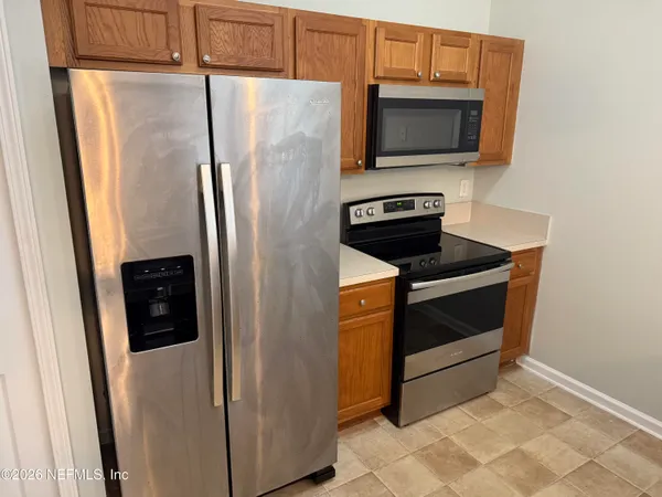a kitchen with stainless steel appliances a refrigerator and microwave