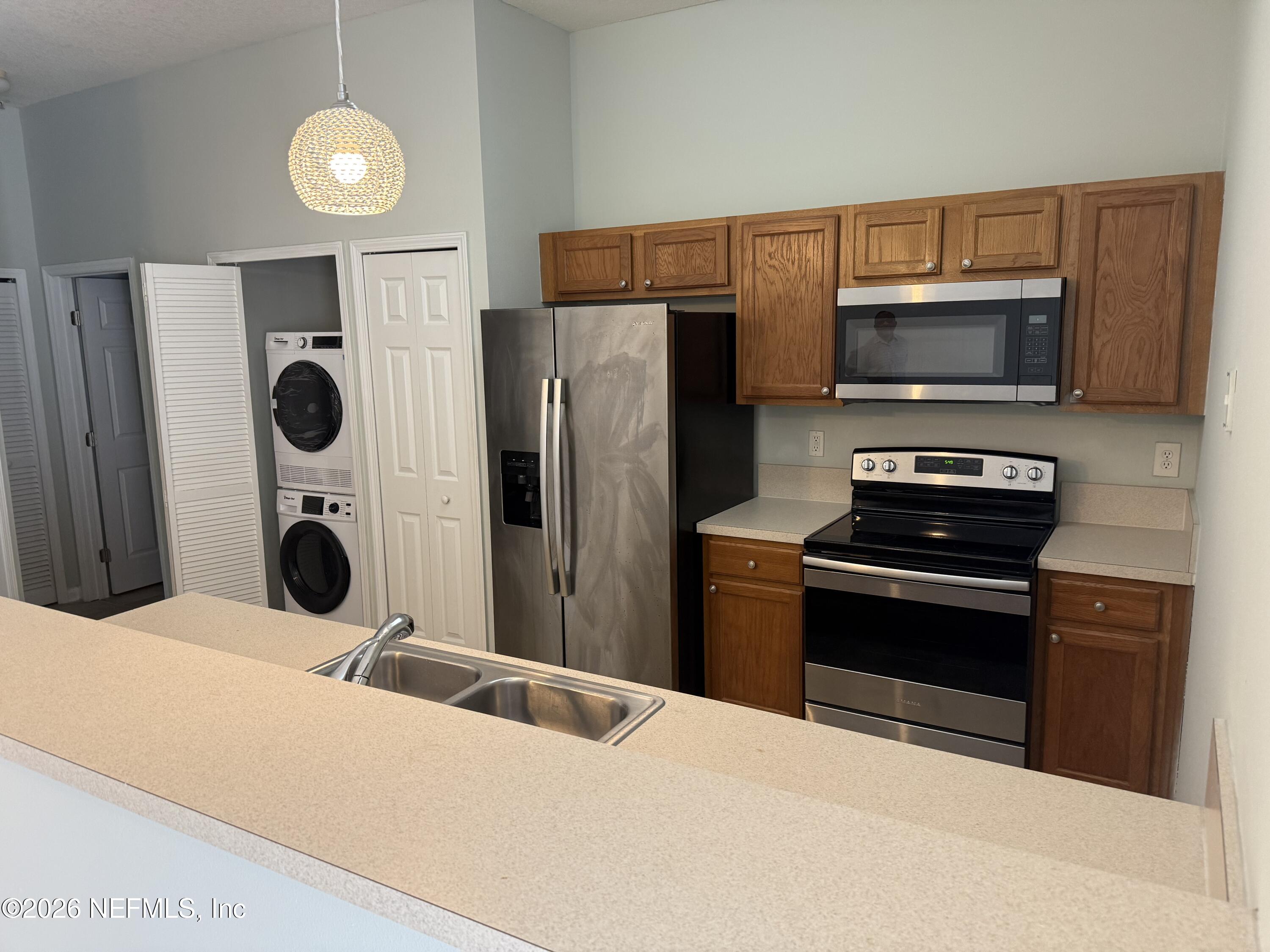 7920 Merrill Road, Unit 403 Jacksonville, FL 32277 - Photo 14 of 18 a kitchen with a refrigerator and a stove top oven