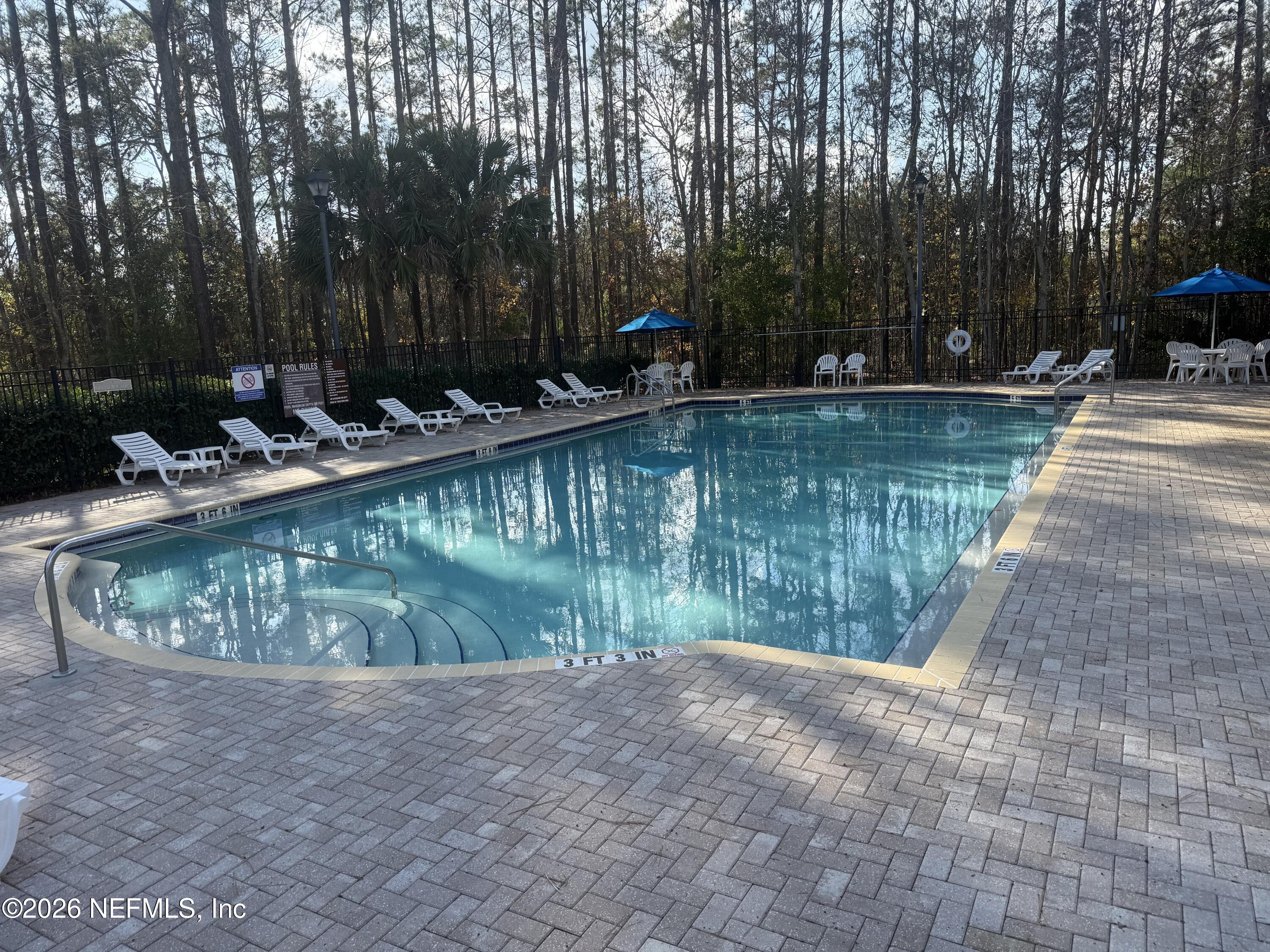 7920 Merrill Road, Unit 403 Jacksonville, FL 32277 - Photo 2 of 18 a view of a lake with a yard and large trees