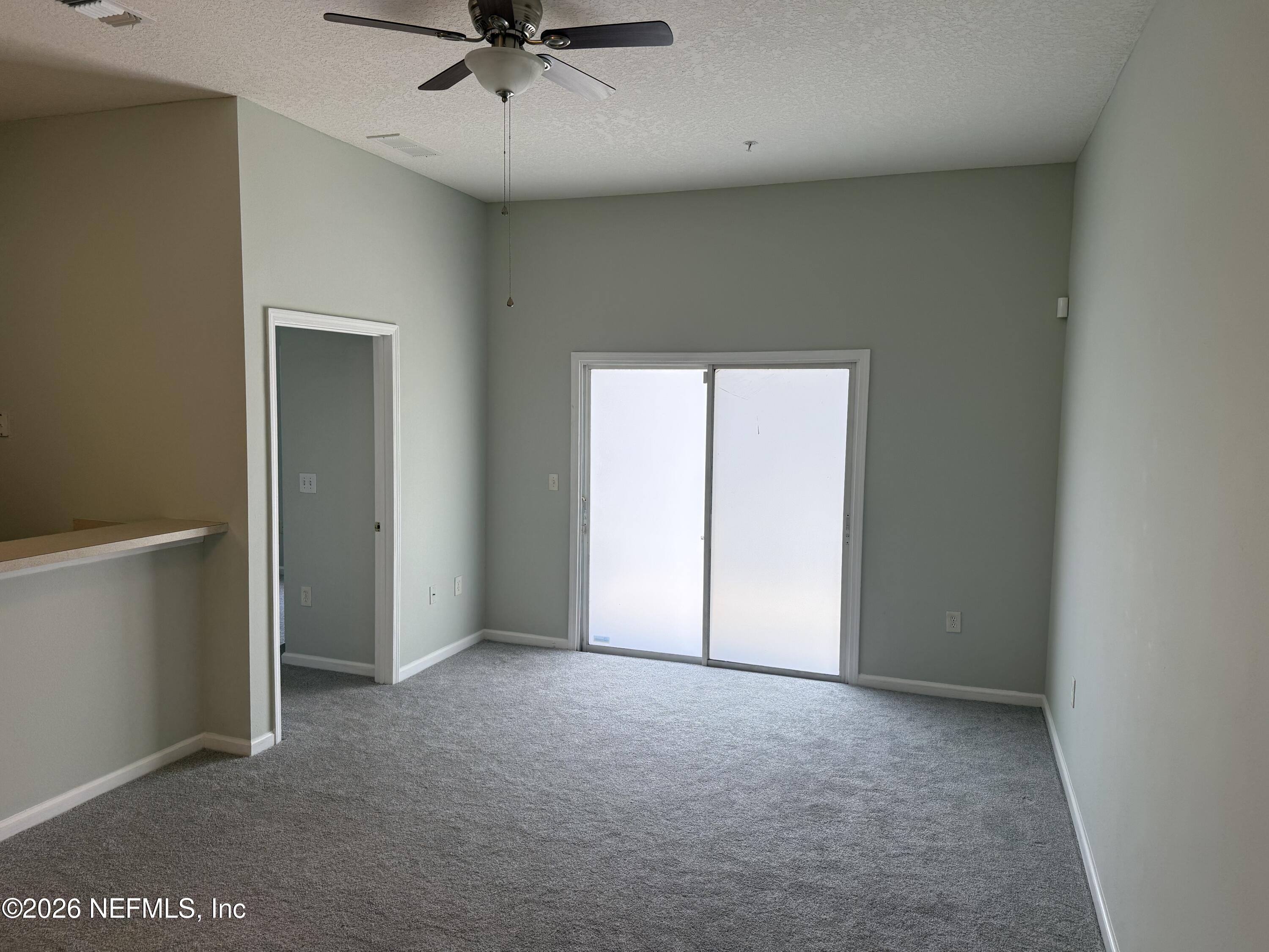 7920 Merrill Road, Unit 403 Jacksonville, FL 32277 - Photo 4 of 18 an empty room with a ceiling fan and carpet