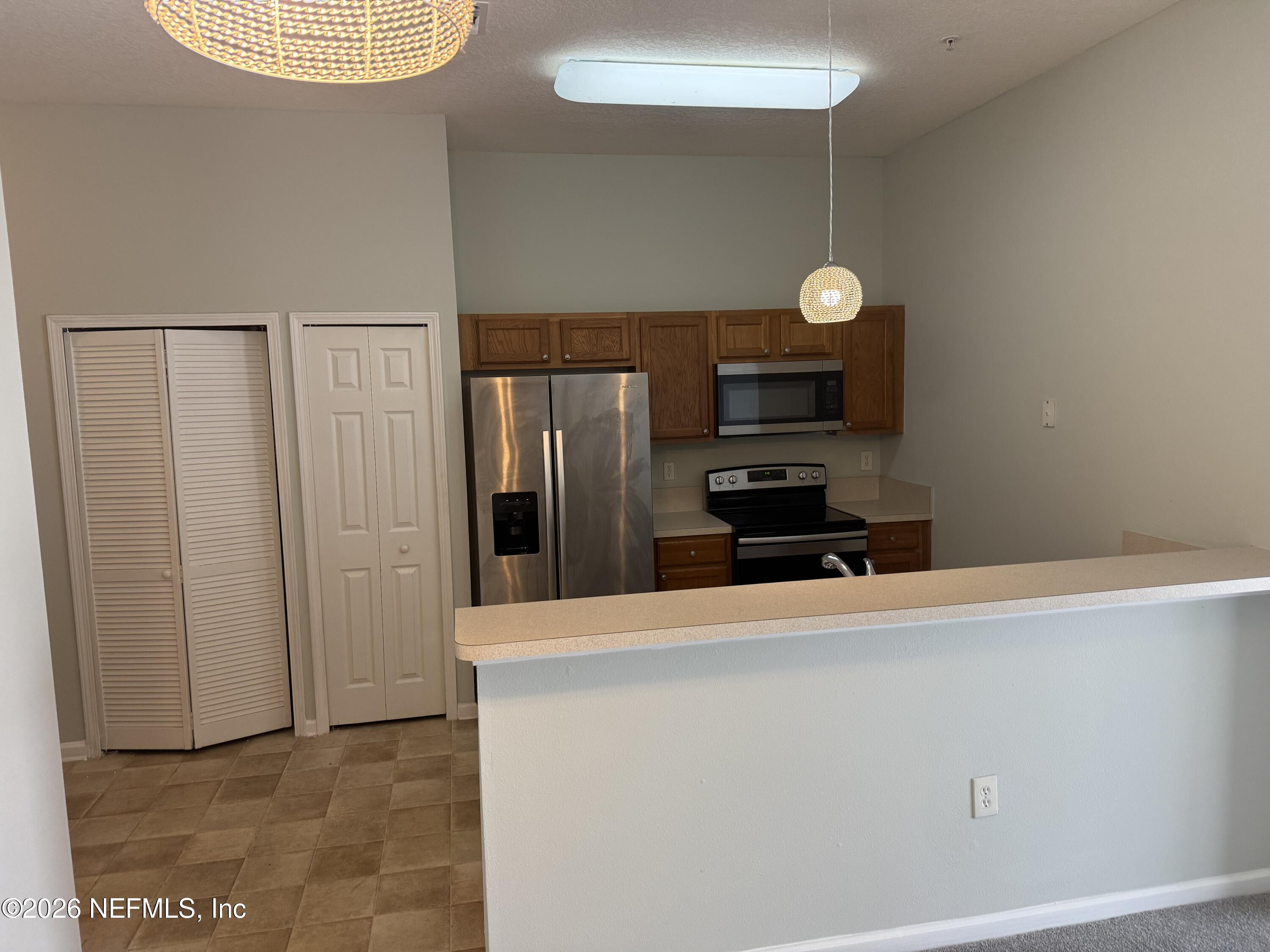 7920 Merrill Road, Unit 403 Jacksonville, FL 32277 - Photo 5 of 18 a kitchen with granite countertop cabinets and refrigerator
