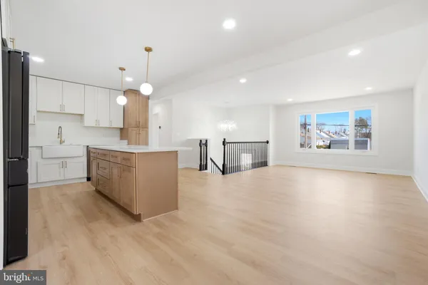 an open kitchen with a refrigerator a stove top oven a large window and white cabinets