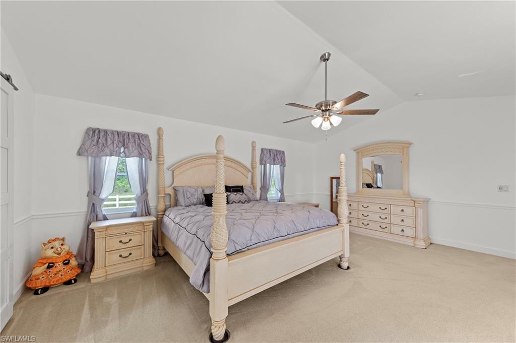 13541 Stringfellow Road Bokeelia, FL 33922 - Photo 13 of 49 a bedroom with a bed and a chandelier